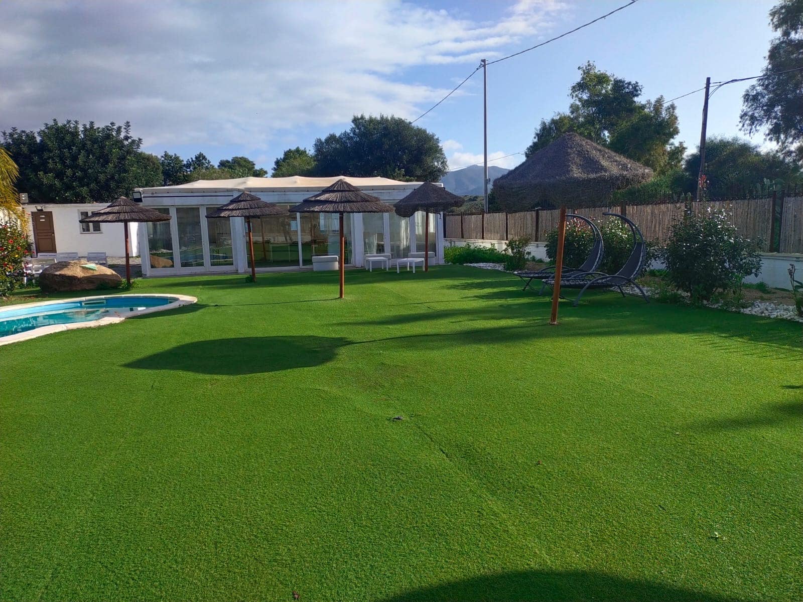 La sala interna vetrata affacciata sul giardino e la piscina